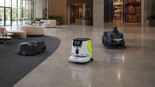 Trois robots de nettoyage commerciaux autonomes opèrent sur des sols durs, de la moquette et dans une zone de service d'entrepôt.